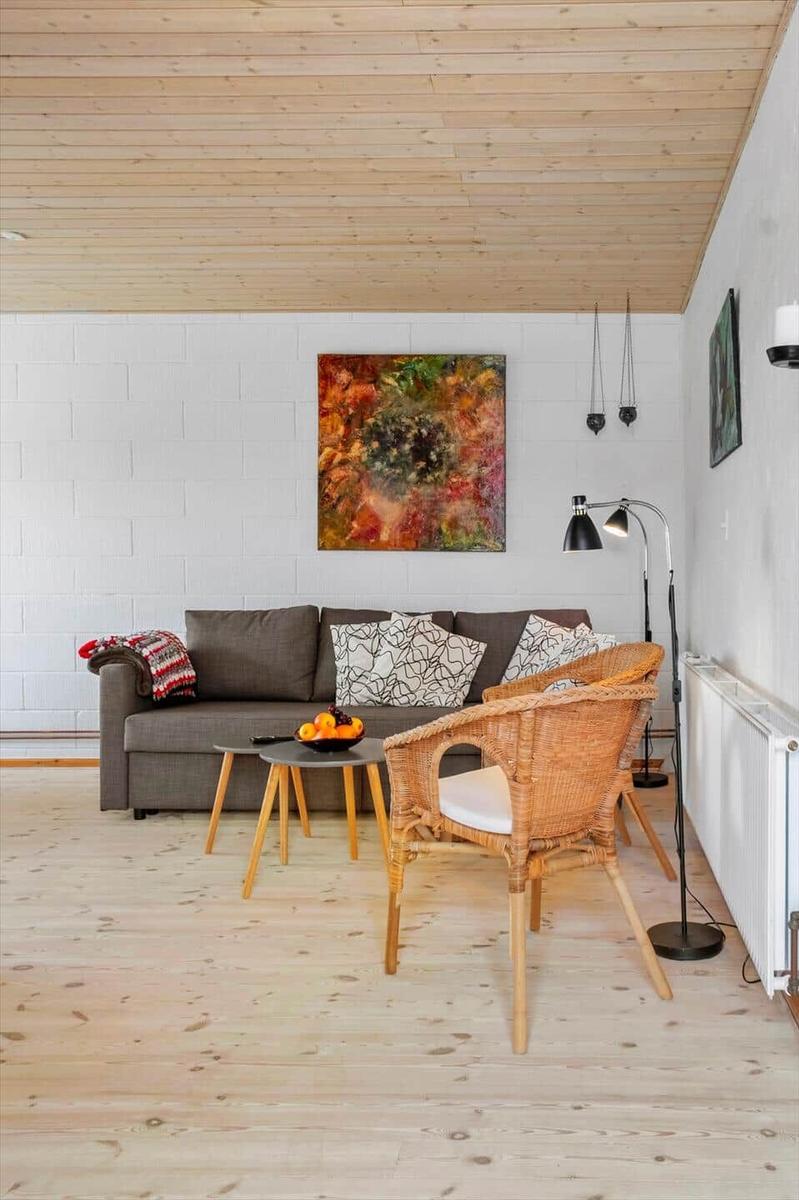 Wohnzimmer mit Sofa, Stuhl und Wandbild.