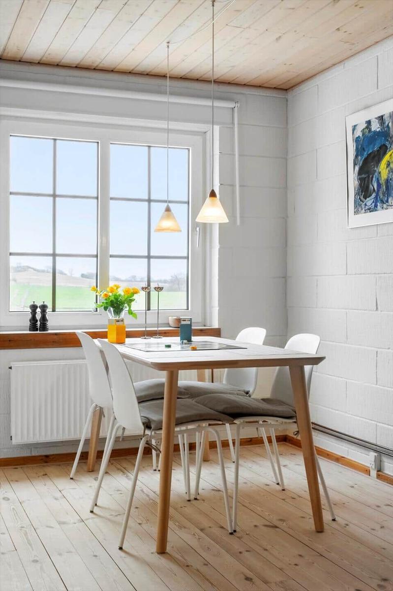 Essbereich mit Tisch, Stühlen und Fenster zum Blick auf das Feld.
