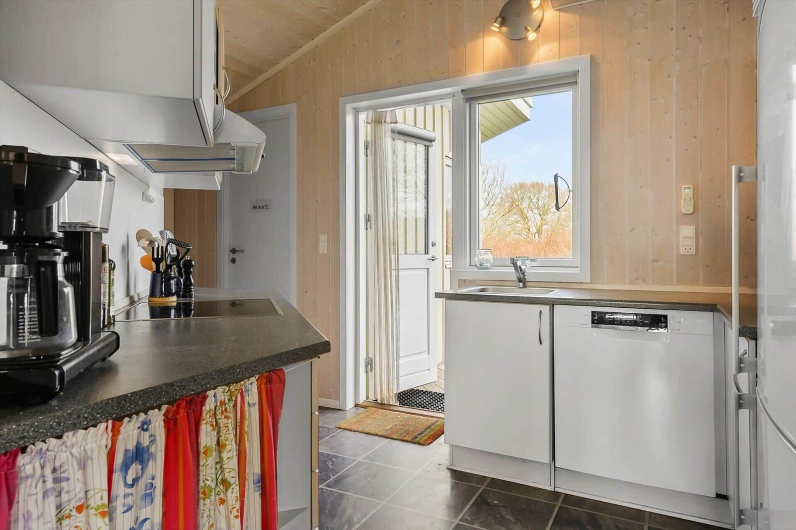 Kitchen with sink, dishwasher, and window to outside door.