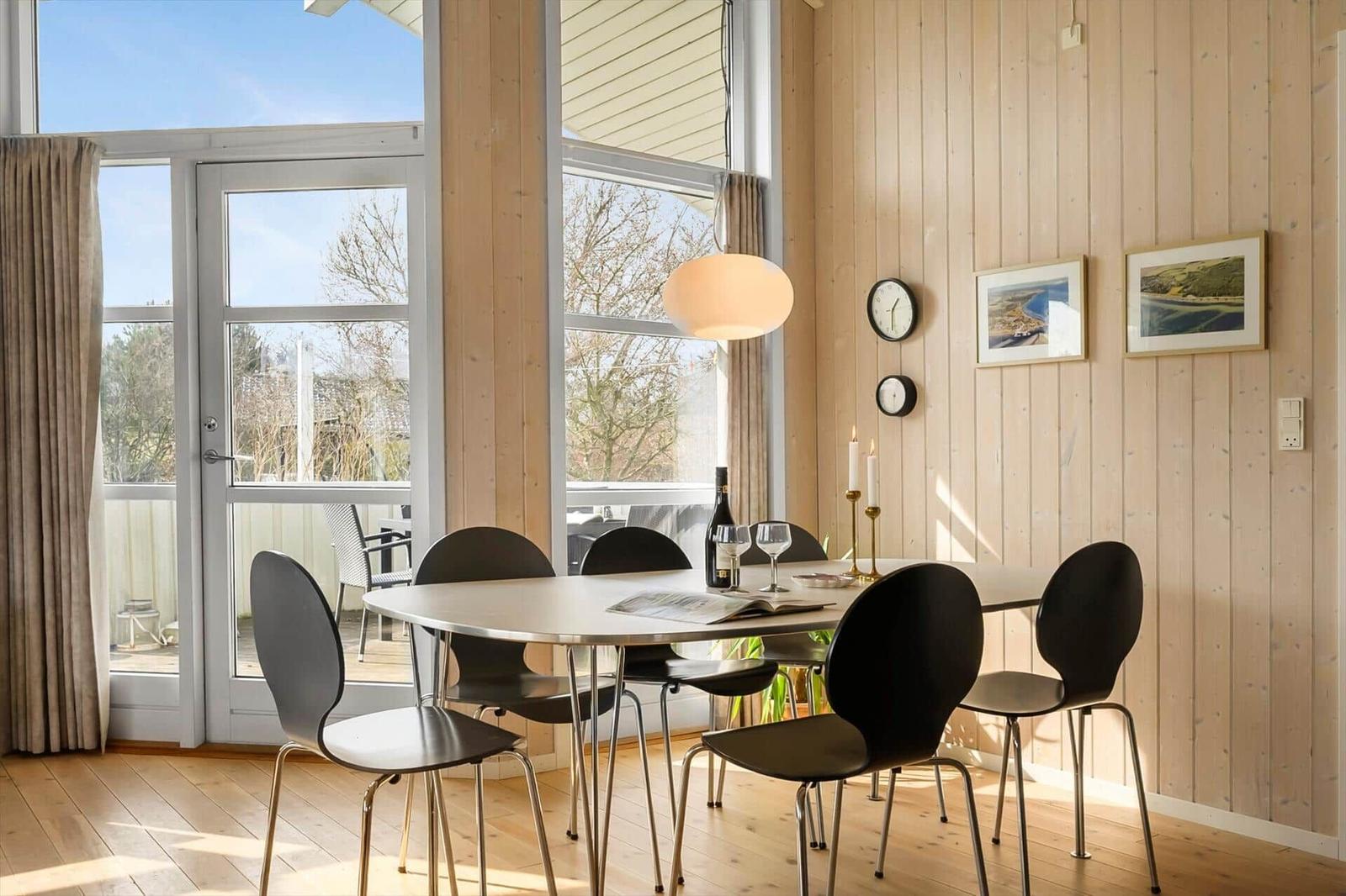 Dining room with table, chairs, and view of balcony.