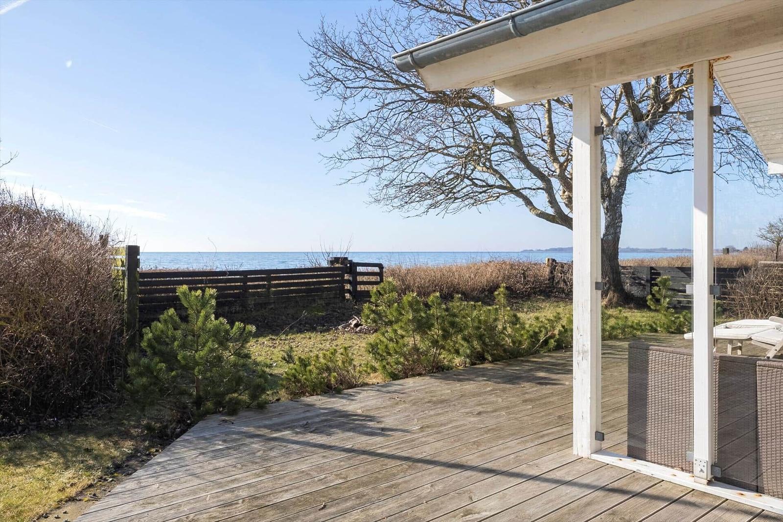 Deck with sea view and a tree.