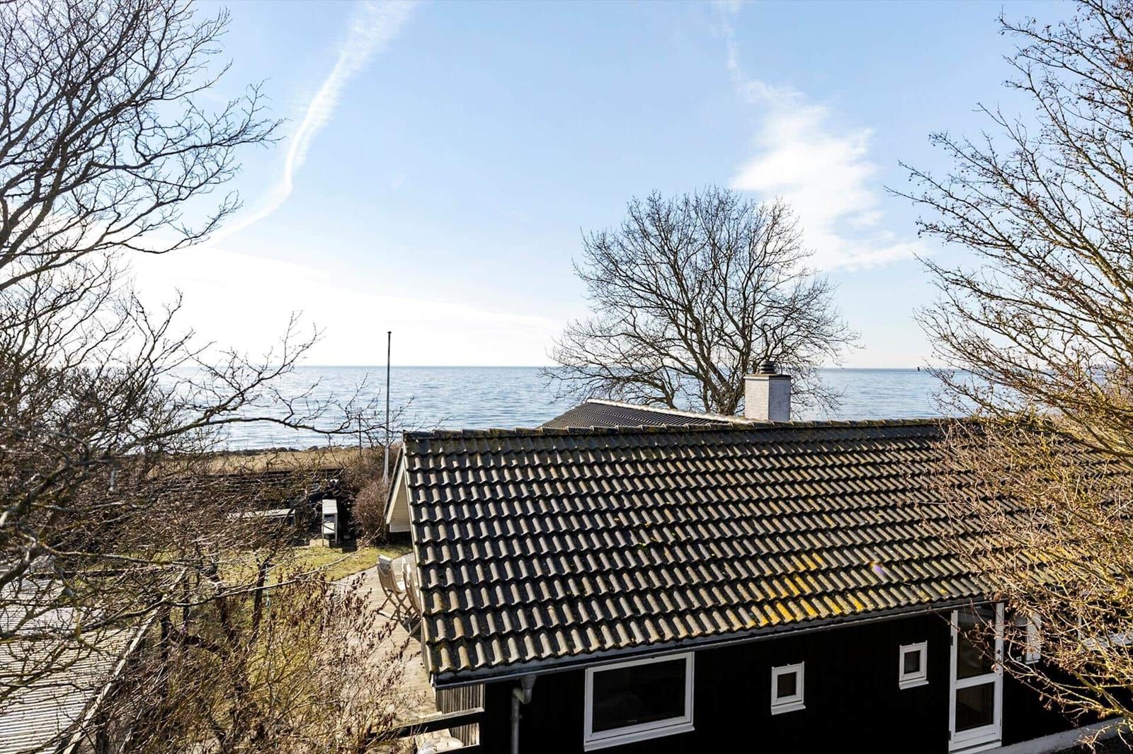 Black house with roof and windows by the water