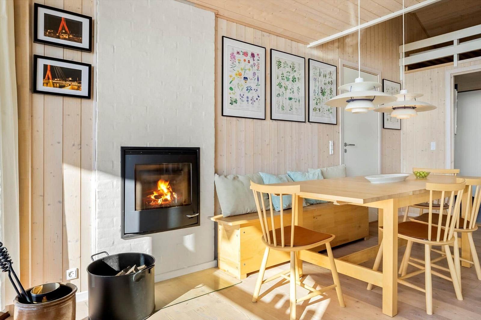Room with dining table, bench, and fireplace against white wall.