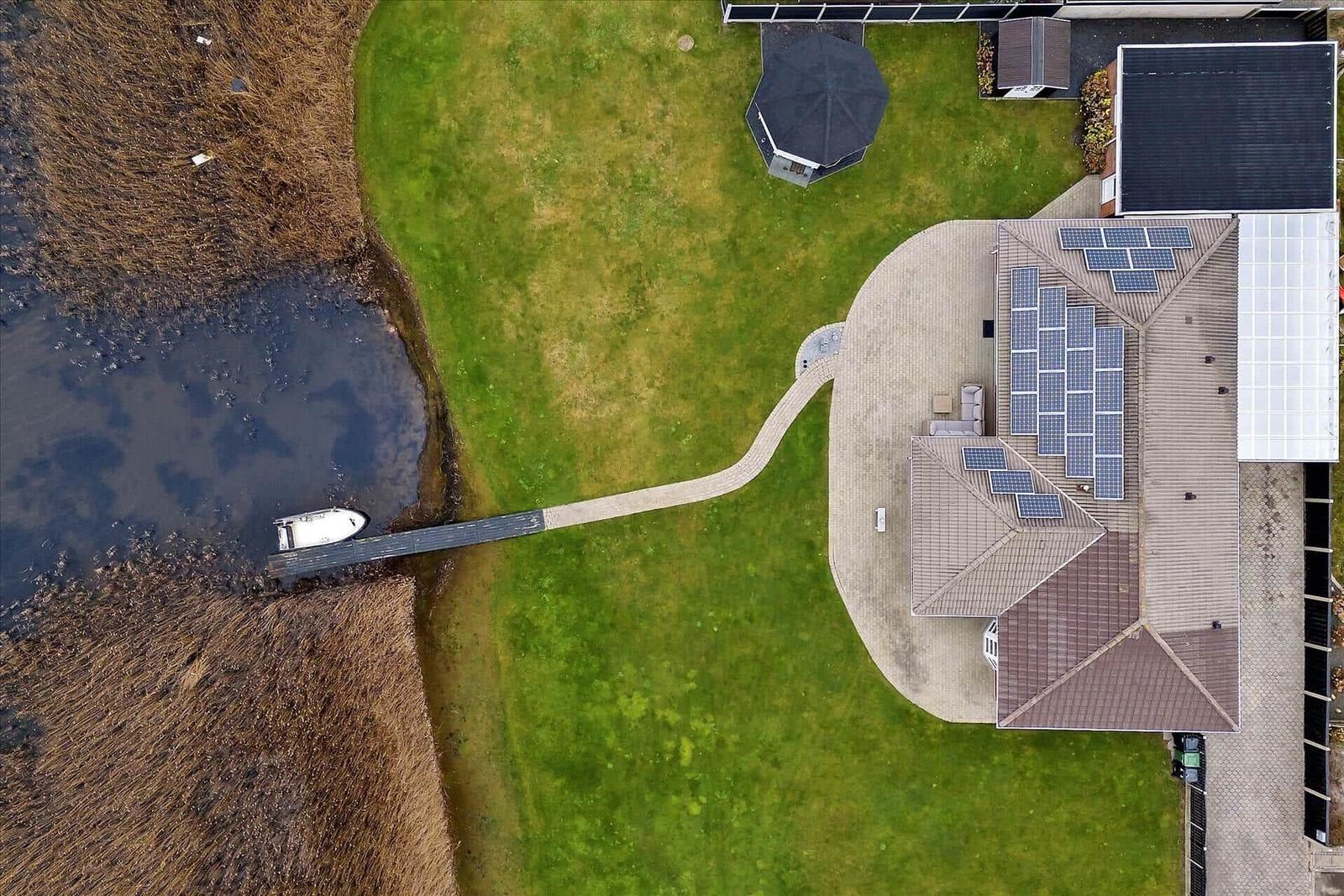 Haus mit Solaranlagen, Bootssteg und großem Garten