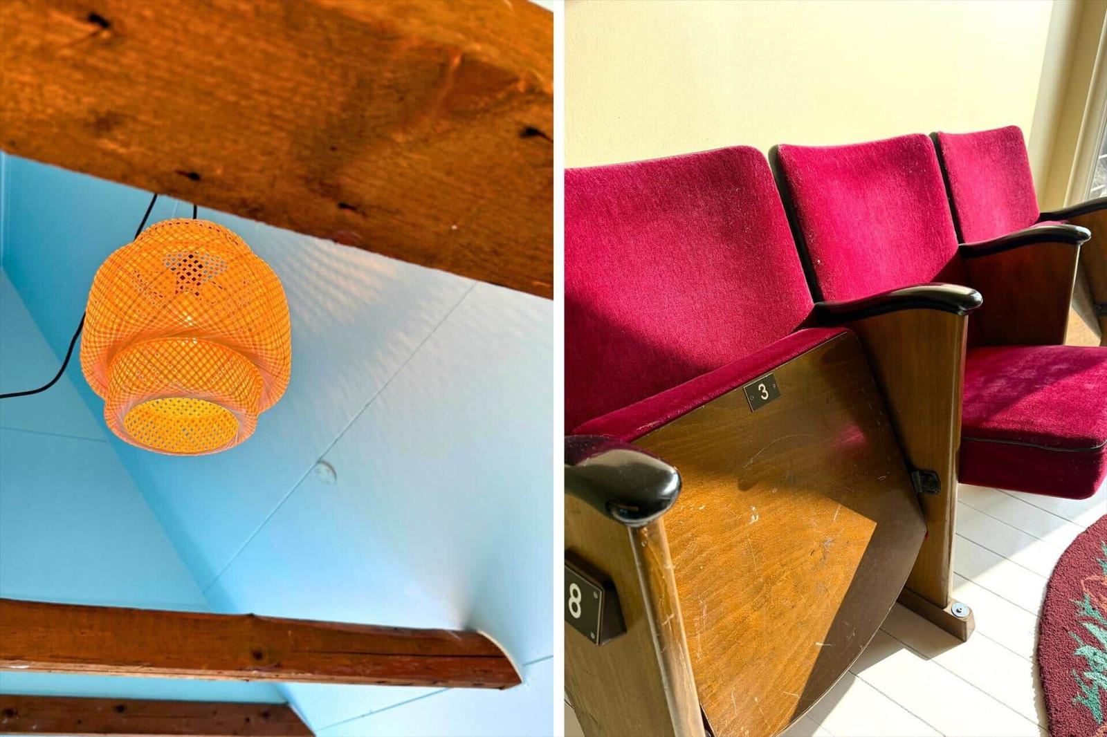 Orange Lampe hängt an Holzkonstruktion. Rote Sitzreihen mit Holzrahmen.