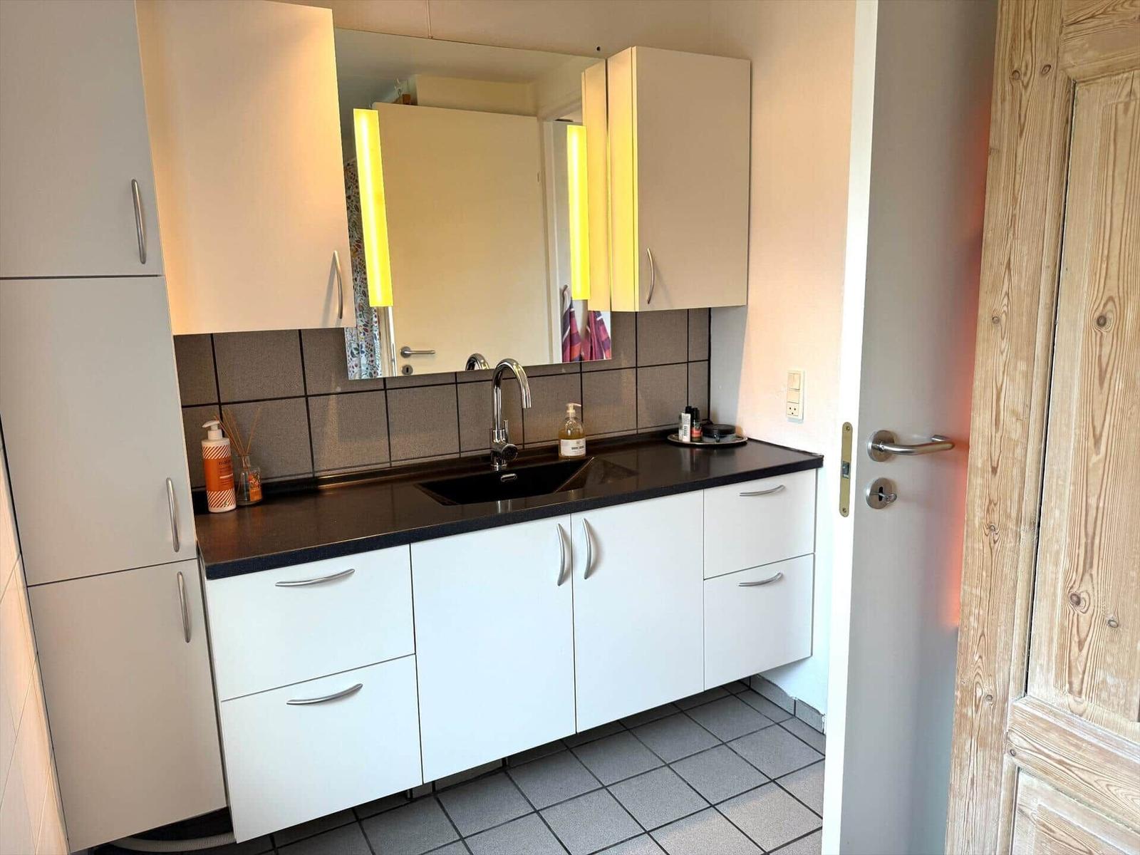 Bad mit Spiegel, Waschbecken und Schränken