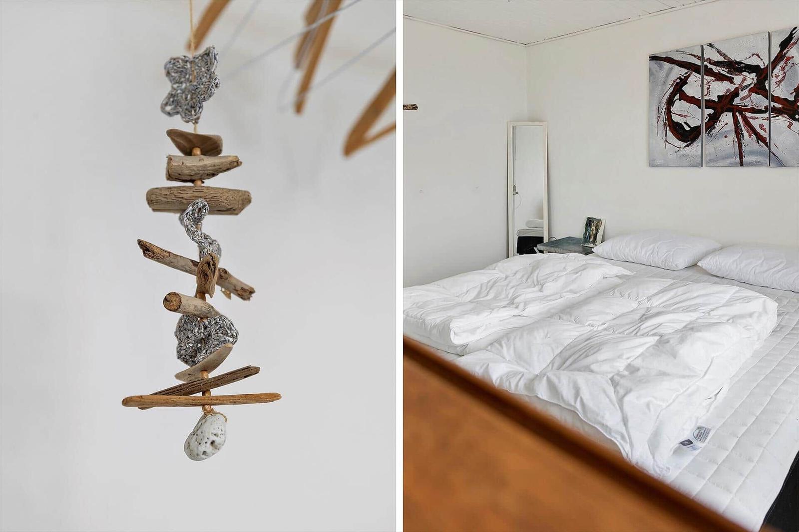 Schlafzimmer mit Bett, Wandbild und Spiegel. Hängendes Dekor aus Holz und Stein.