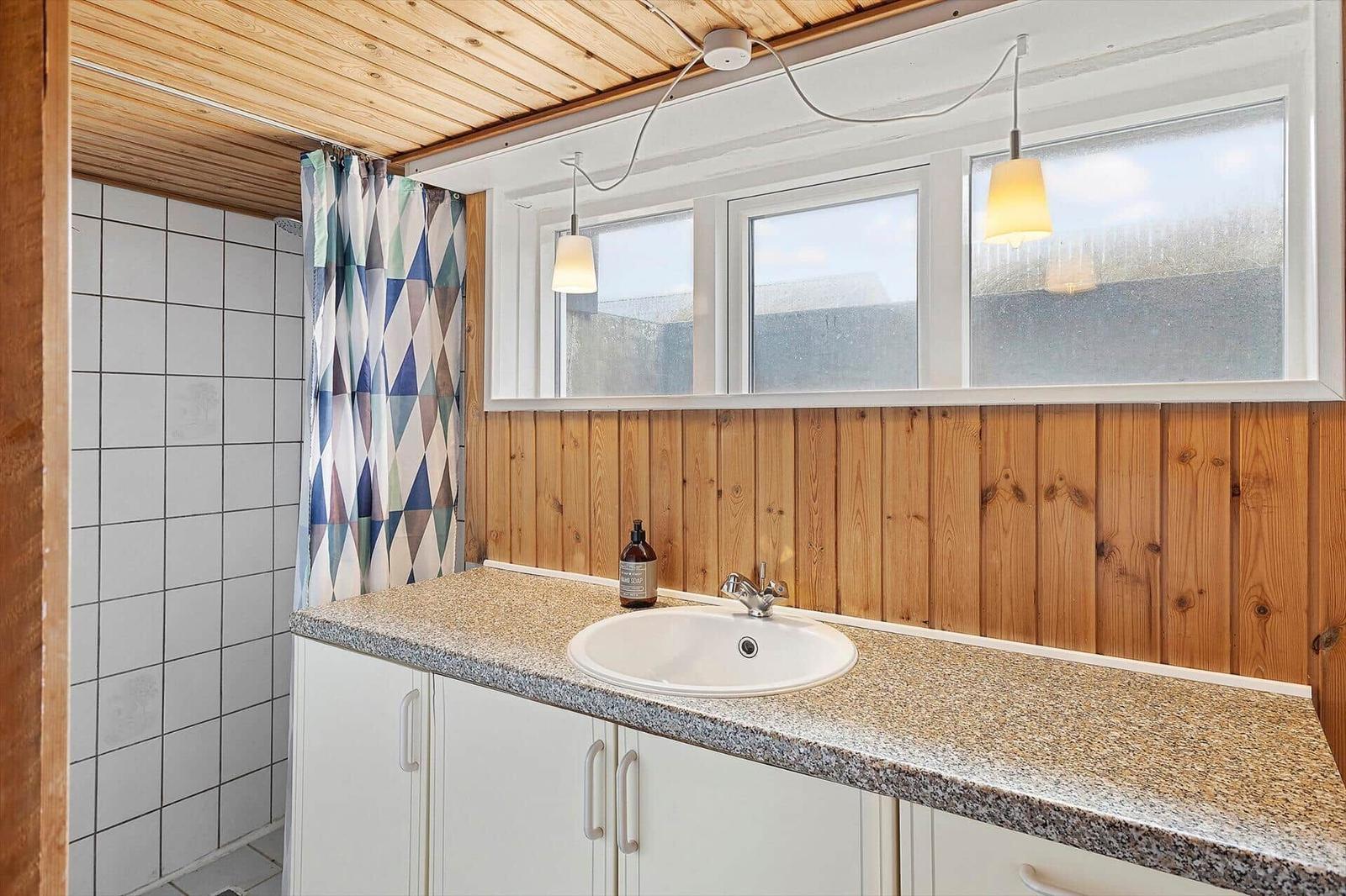 Bad mit Waschbecken, Dusche und Fenster