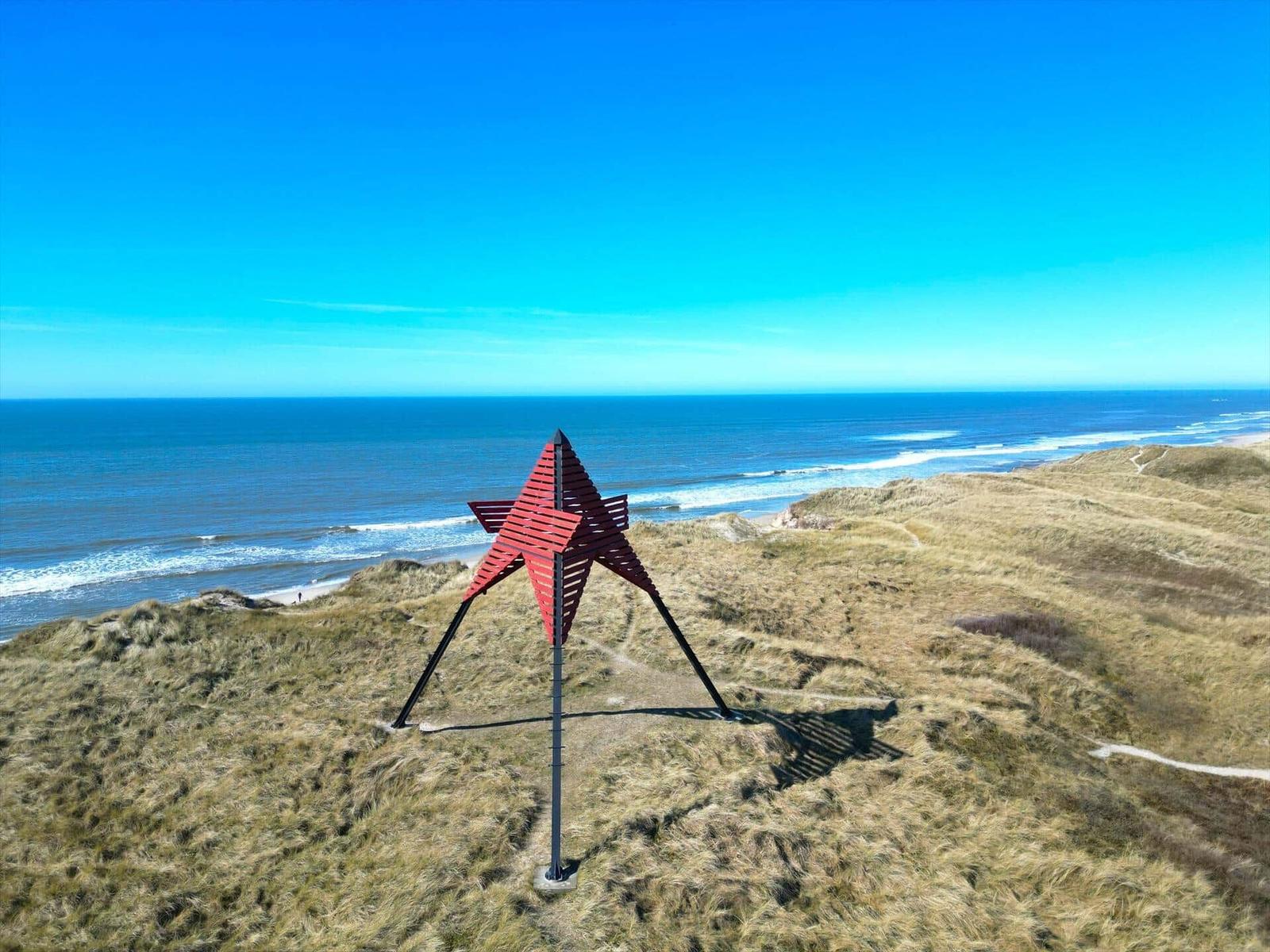 Roter Stern auf Dünen mit Blick auf das Meer.