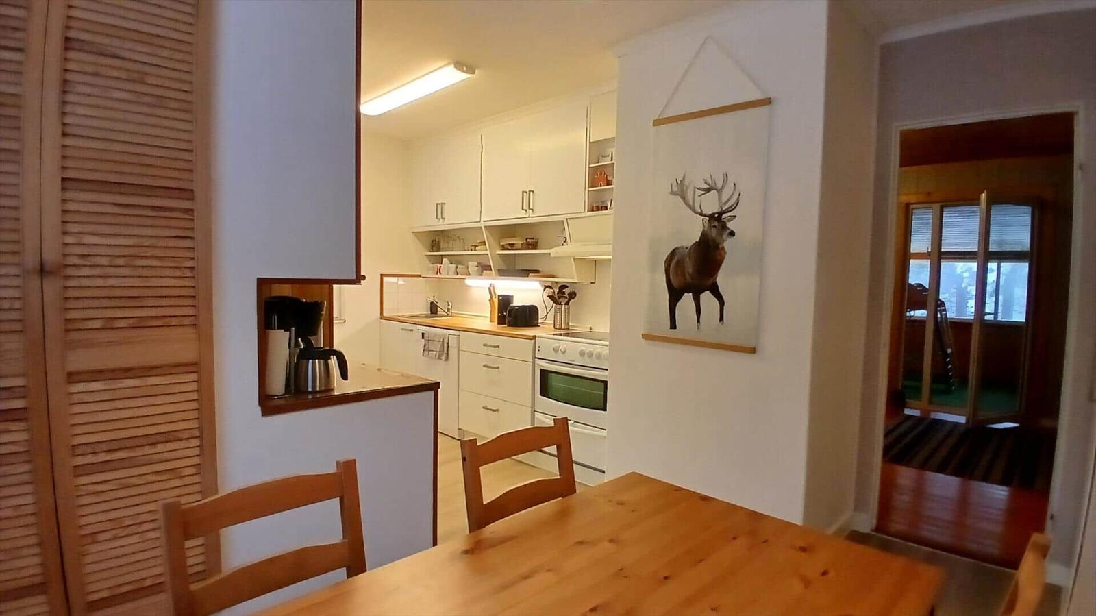 Küche mit Essbereich und Wandbild eines Hirsches