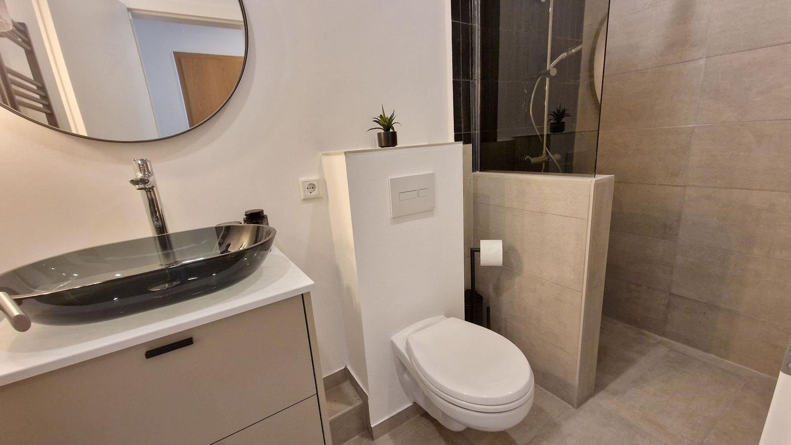 Badezimmer mit Waschbecken, Toilette und Dusche.
