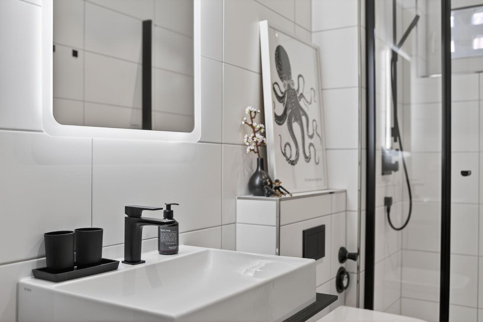 Badezimmer mit Waschbecken, Spiegel und Dusche