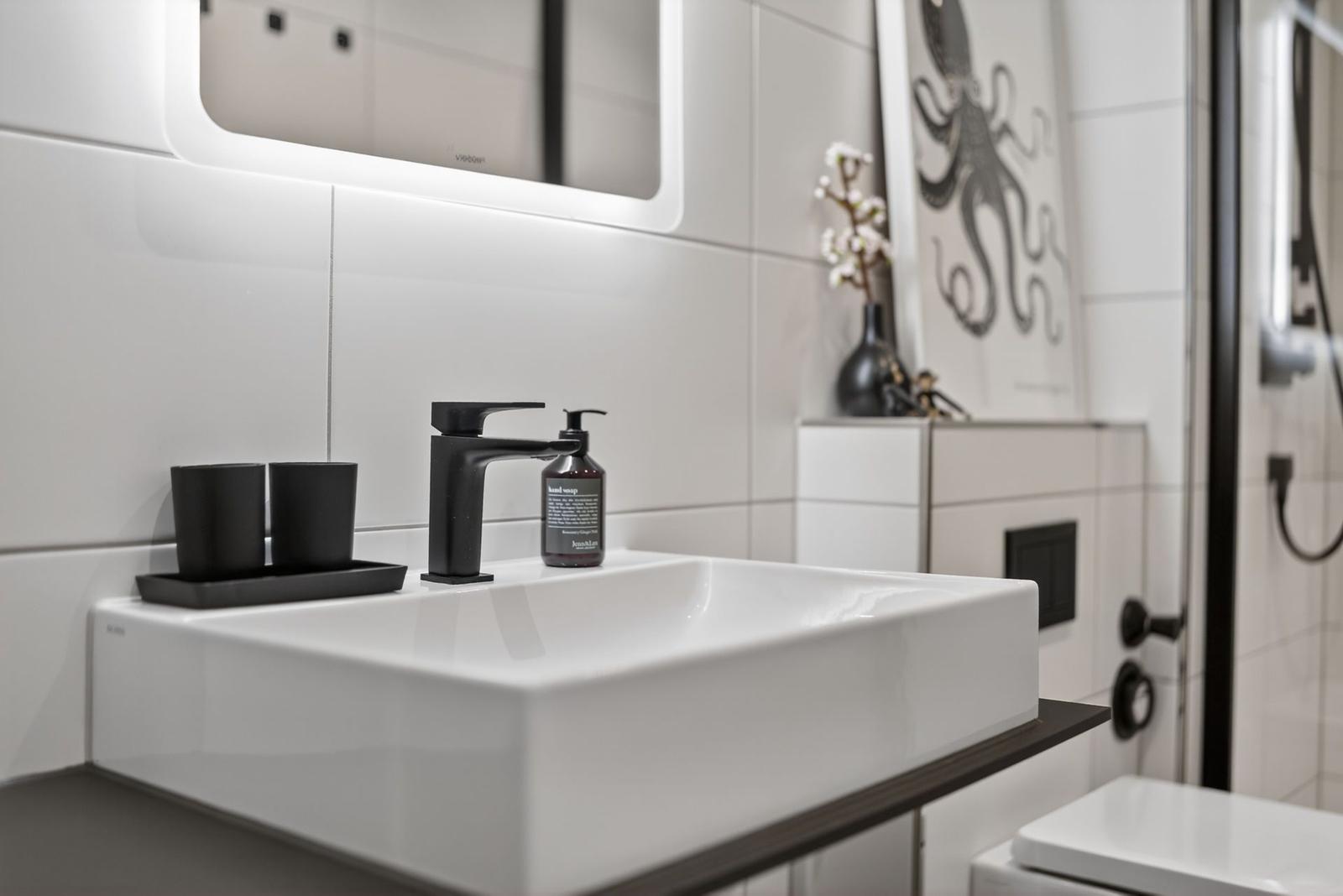 Badezimmer mit Waschbecken, Spiegel und Dusche