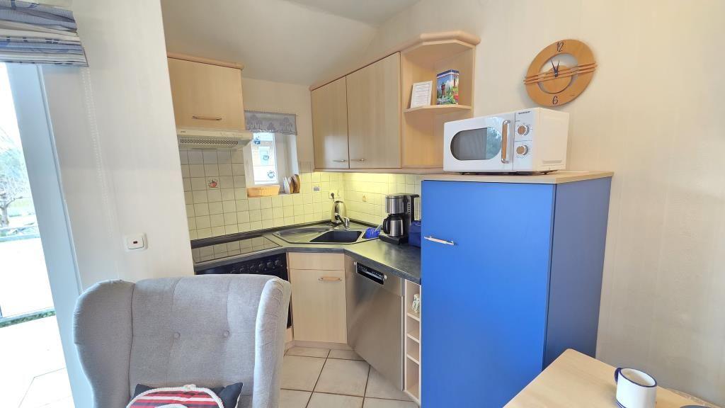 Küche mit blauem Kühlschrank, Mikrowelle und Arbeitsplatte