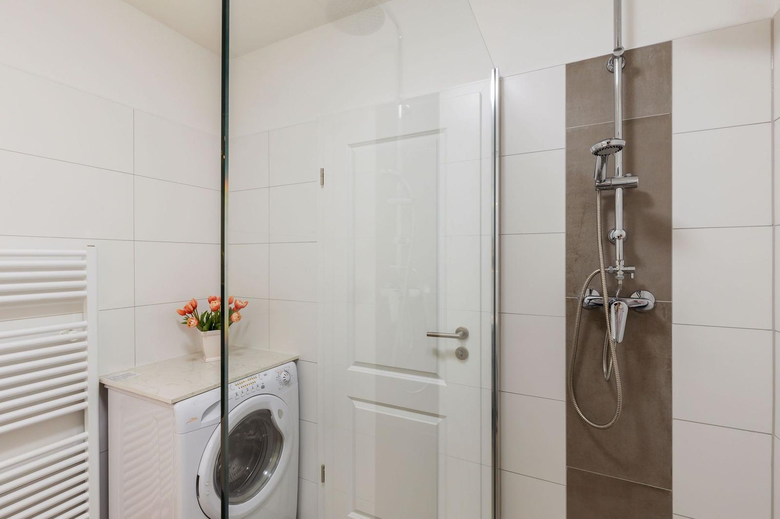 Bad mit Dusche, Waschmaschine und Heizung.