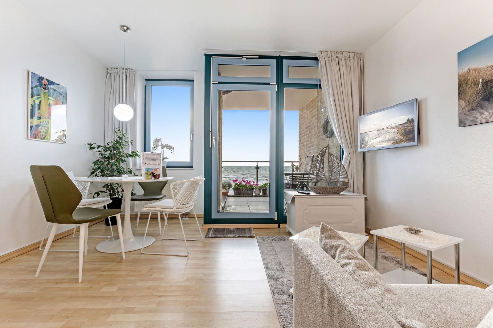Wohnzimmer mit Essbereich und Balkonblick aufs Meer.