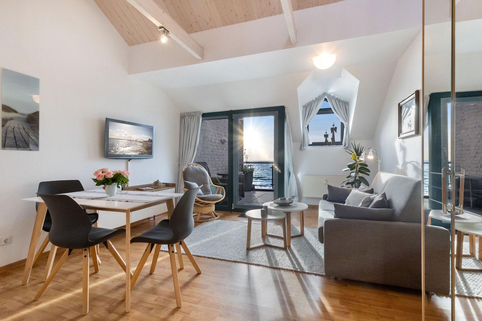 Wohn- und Essbereich mit Blick aufs Meer und Balkon.