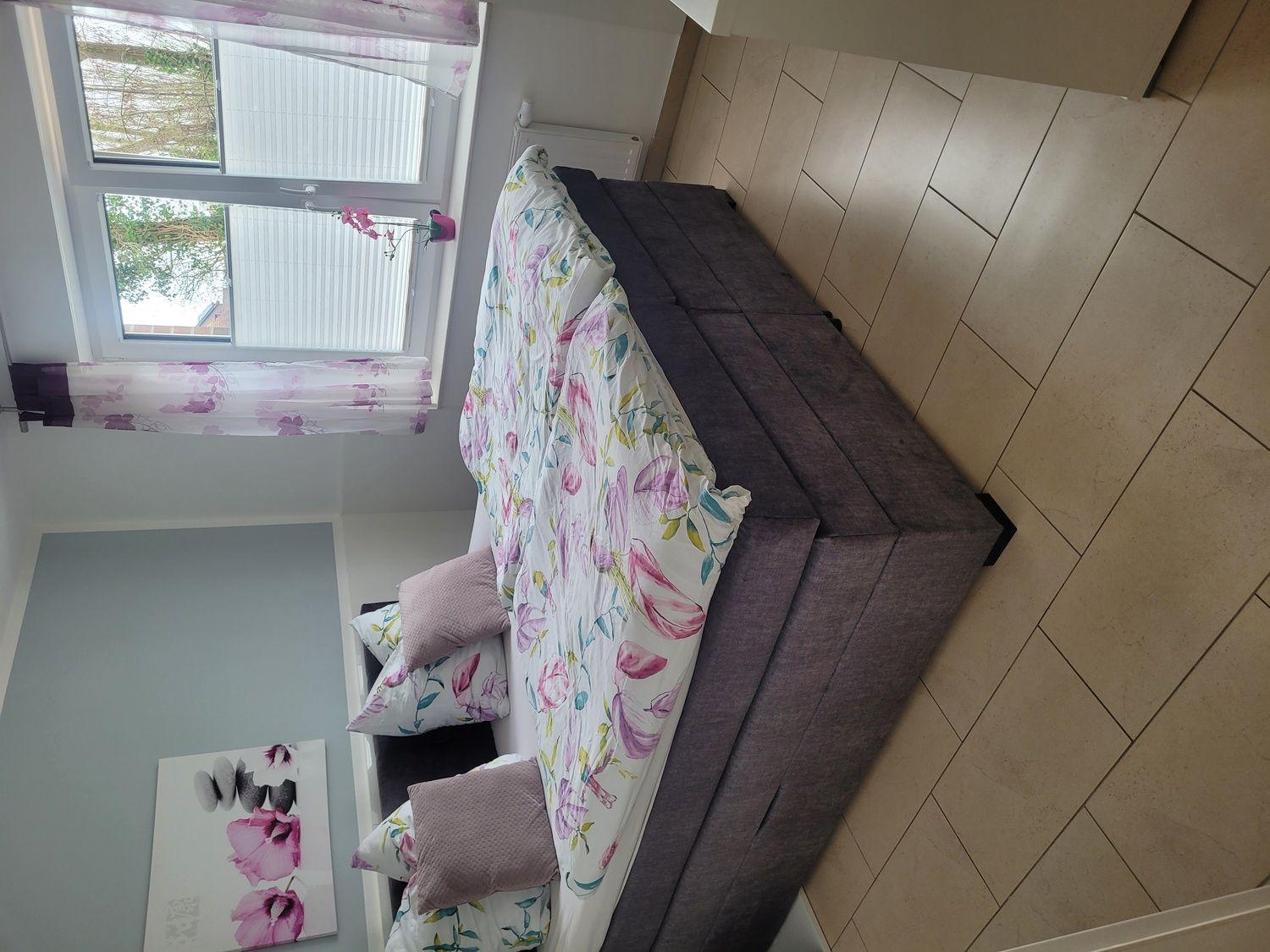 Schlafzimmer mit Bett, Fenster und Wandbild