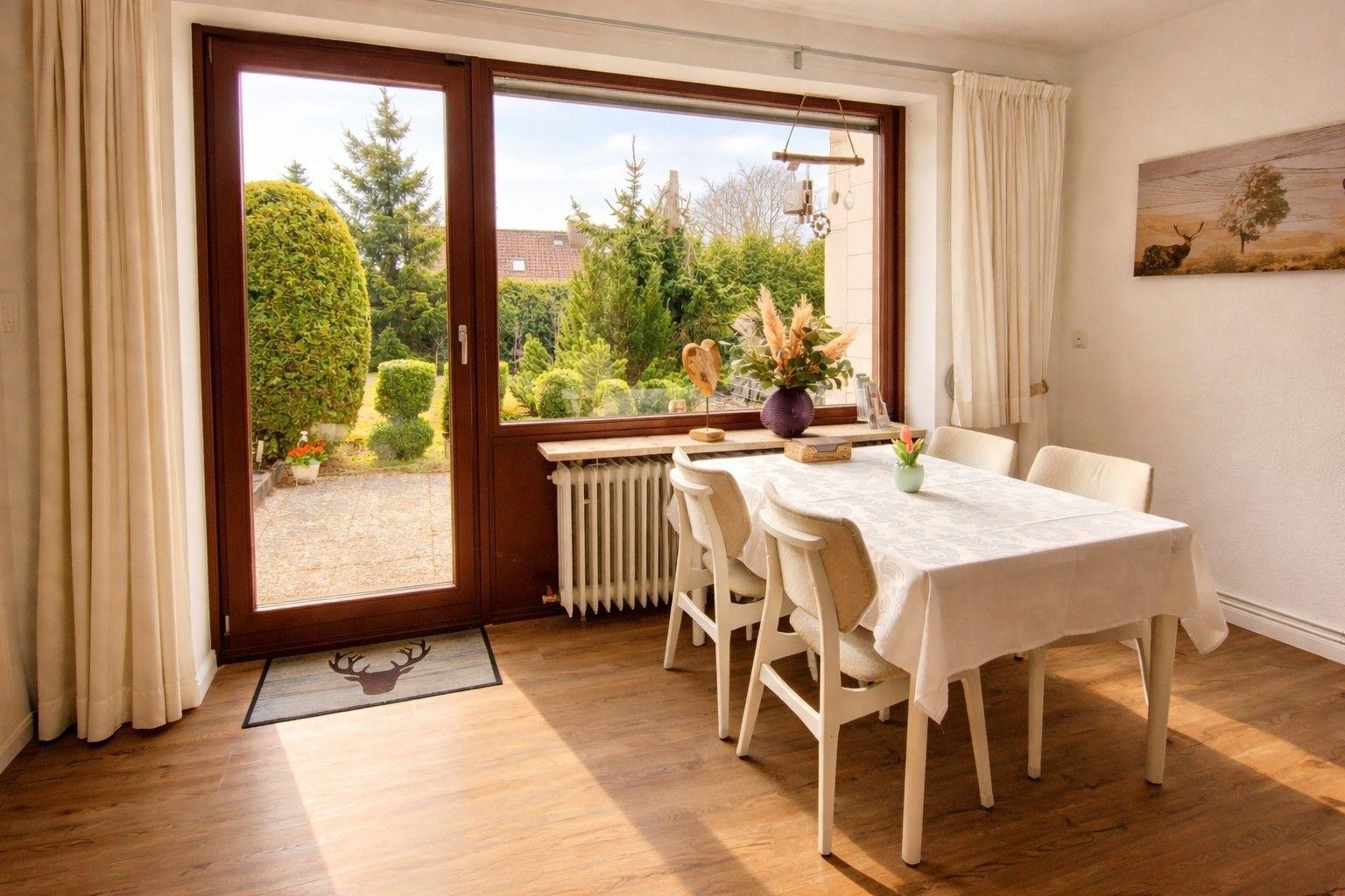 Esszimmer mit Tisch, Stühlen und Blick auf den Garten.