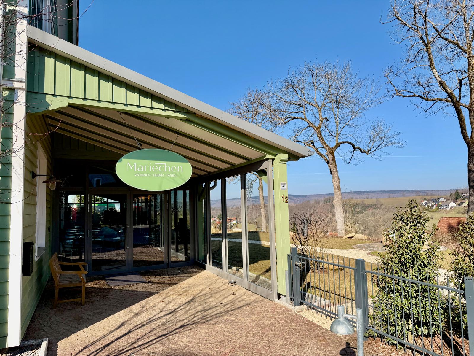 Eingangsbereich mit Schild und Blick auf die Landschaft