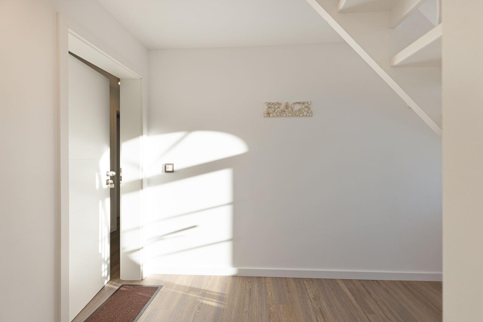 Eingangsbereich mit Holzboden, Wanddekoration und Treppe.