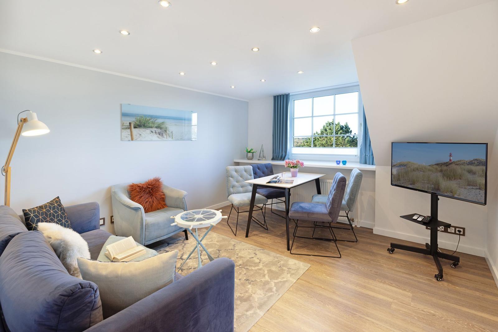 Wohnzimmer mit Sofa, Esstisch, Fernseher und Fenster mit Blick.