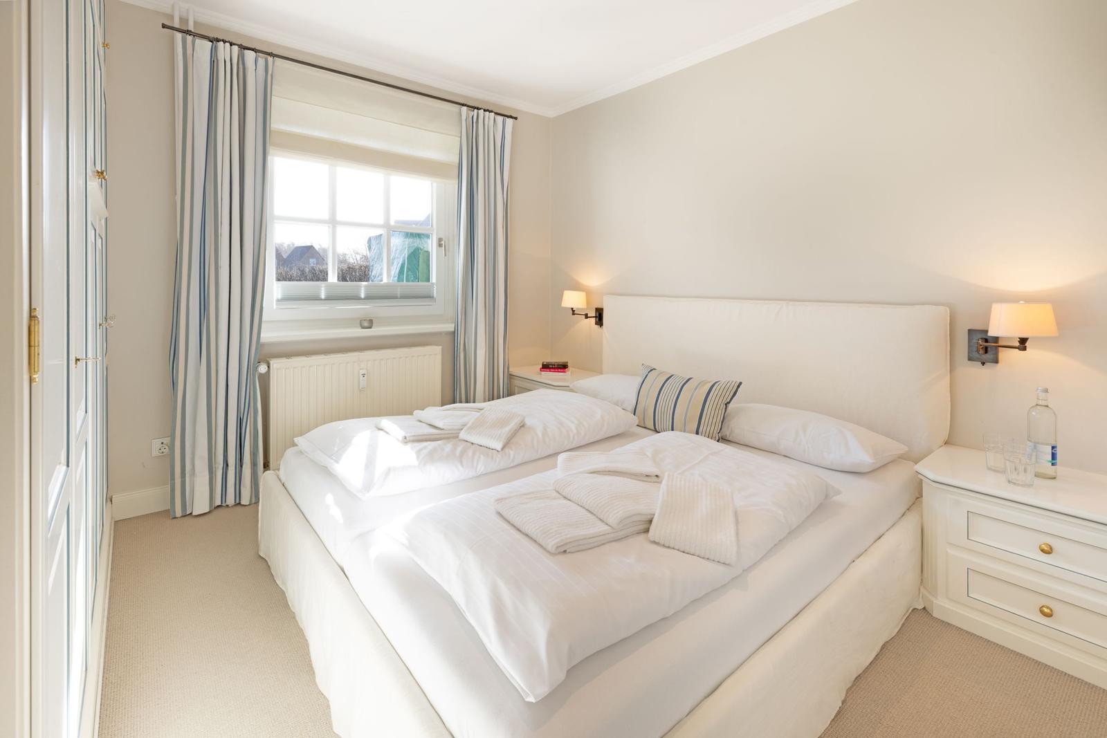 Schlafzimmer mit Doppelbett, Fenster und Nachttisch