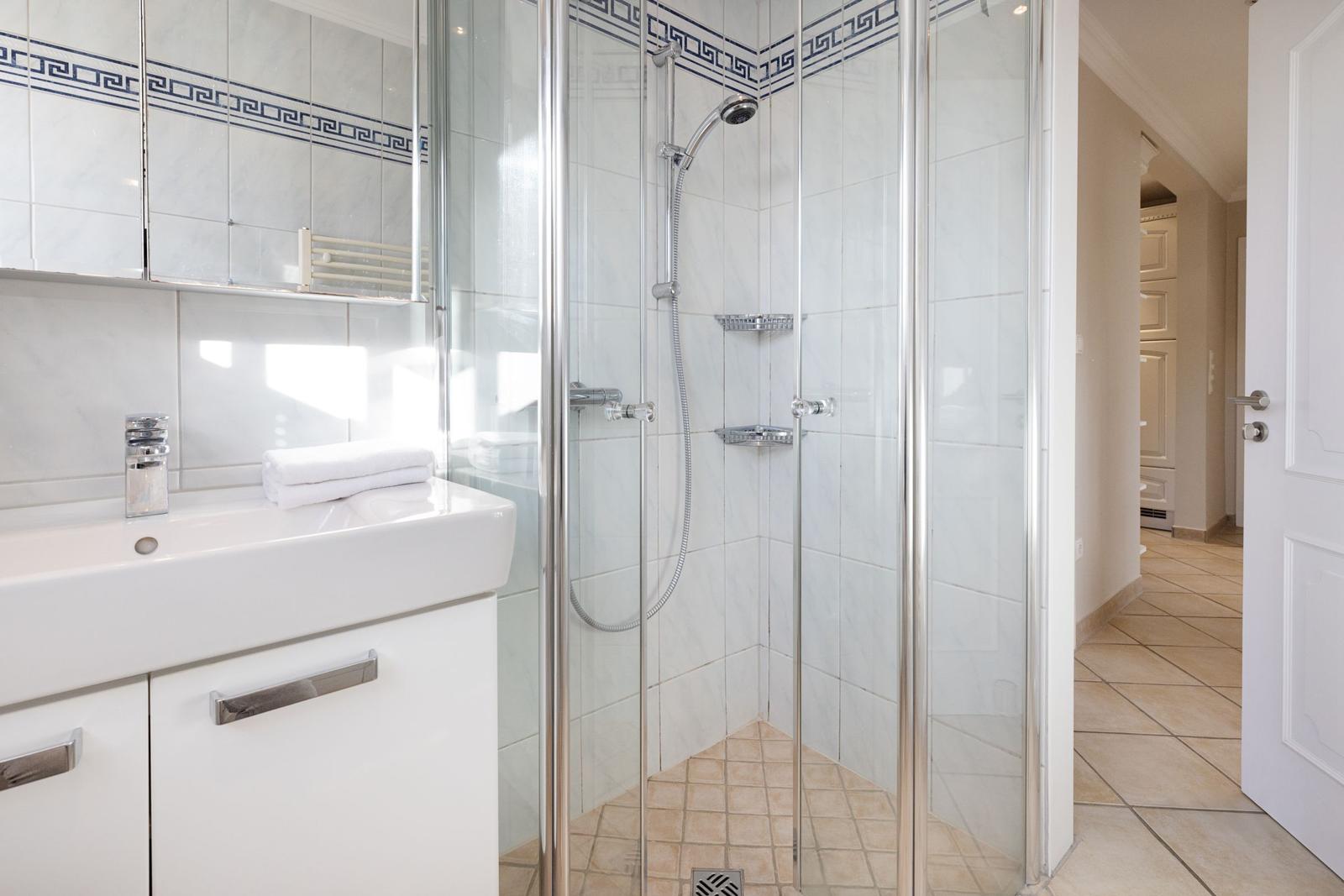 Badezimmer mit Dusche und Waschbecken