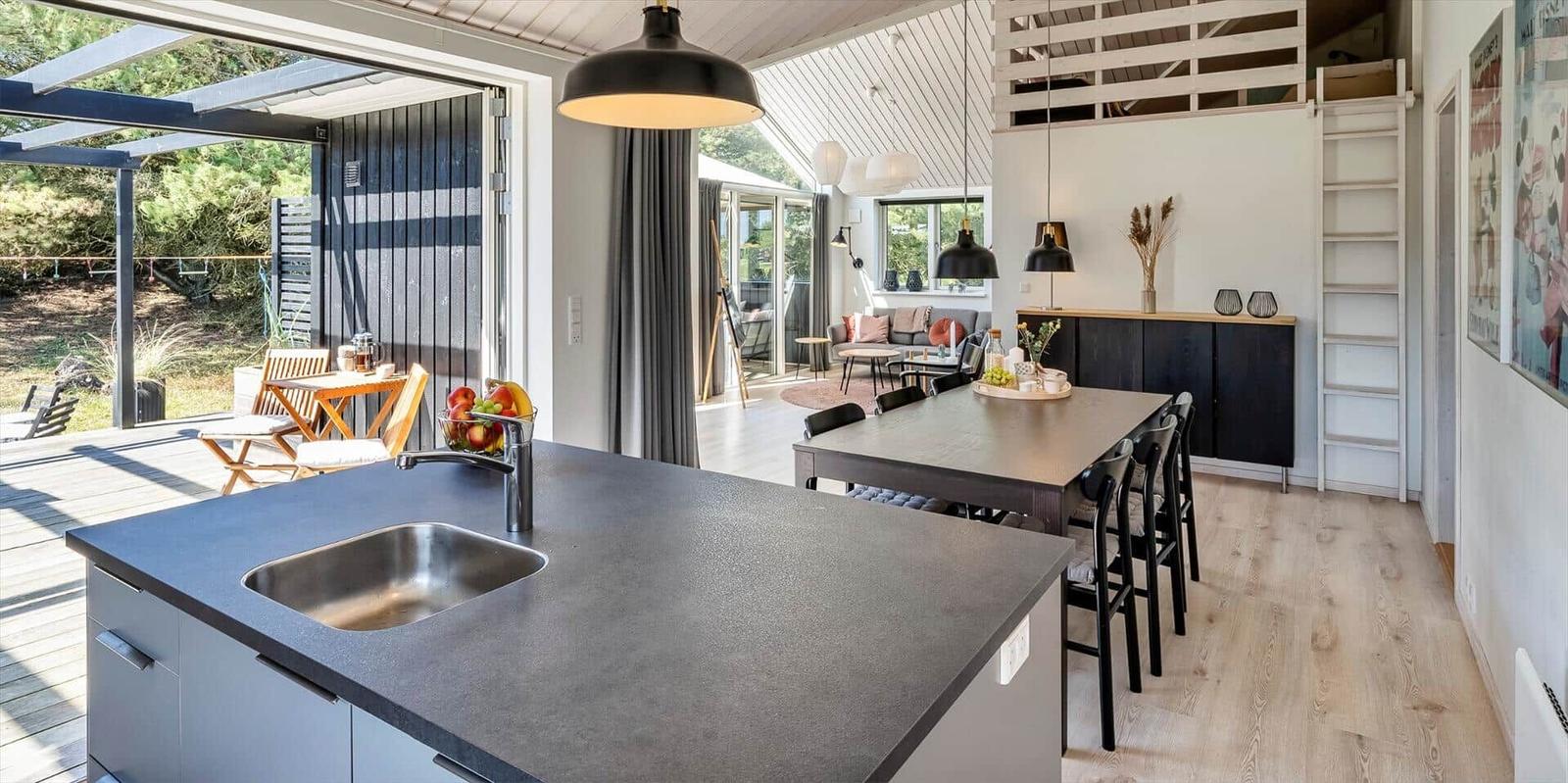 Küche mit Essbereich, Terrasse und Wohnzimmer im Hintergrund.