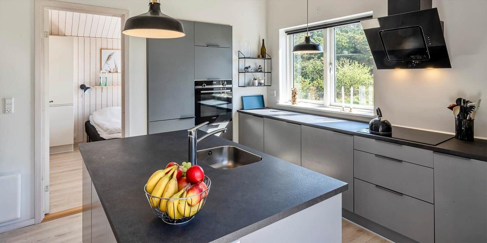 Küche mit Arbeitsplatte, Spüle und Obstschale. Durchgang zur Schlafzimmer.