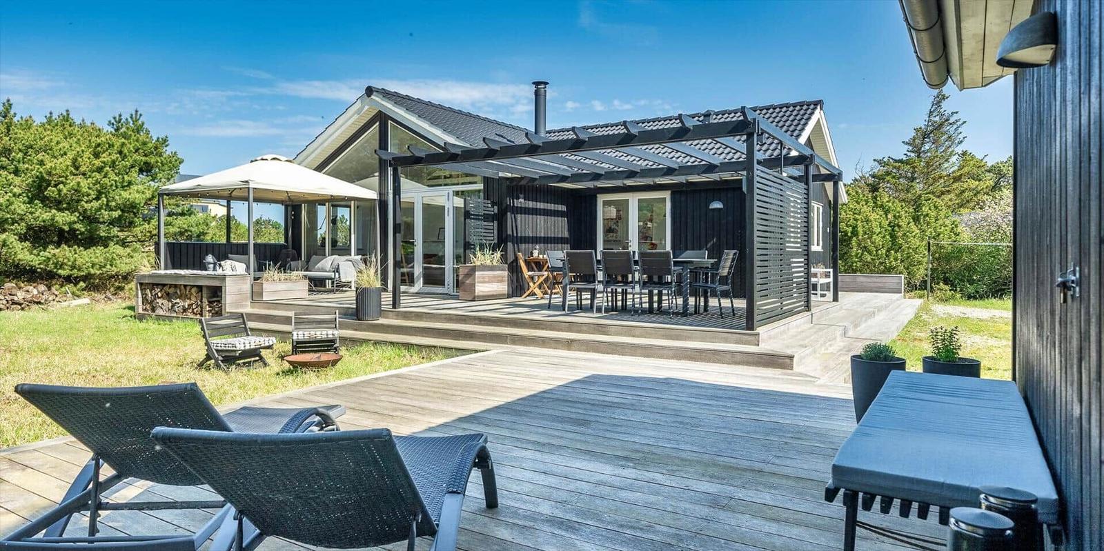 Moderne Ferienwohnung mit Terrasse, Sitzgelegenheiten und Grillplatz im Freien.
