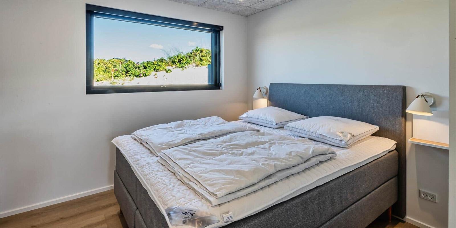 Schlafzimmer mit Bett, Fenster und Nachttischen