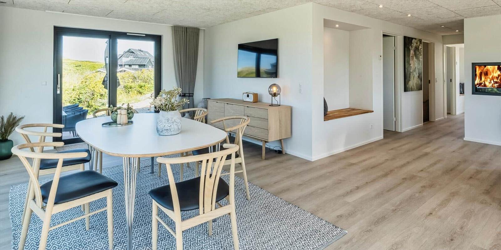 Esszimmer mit Tisch, Stühlen und Blick auf die Landschaft.