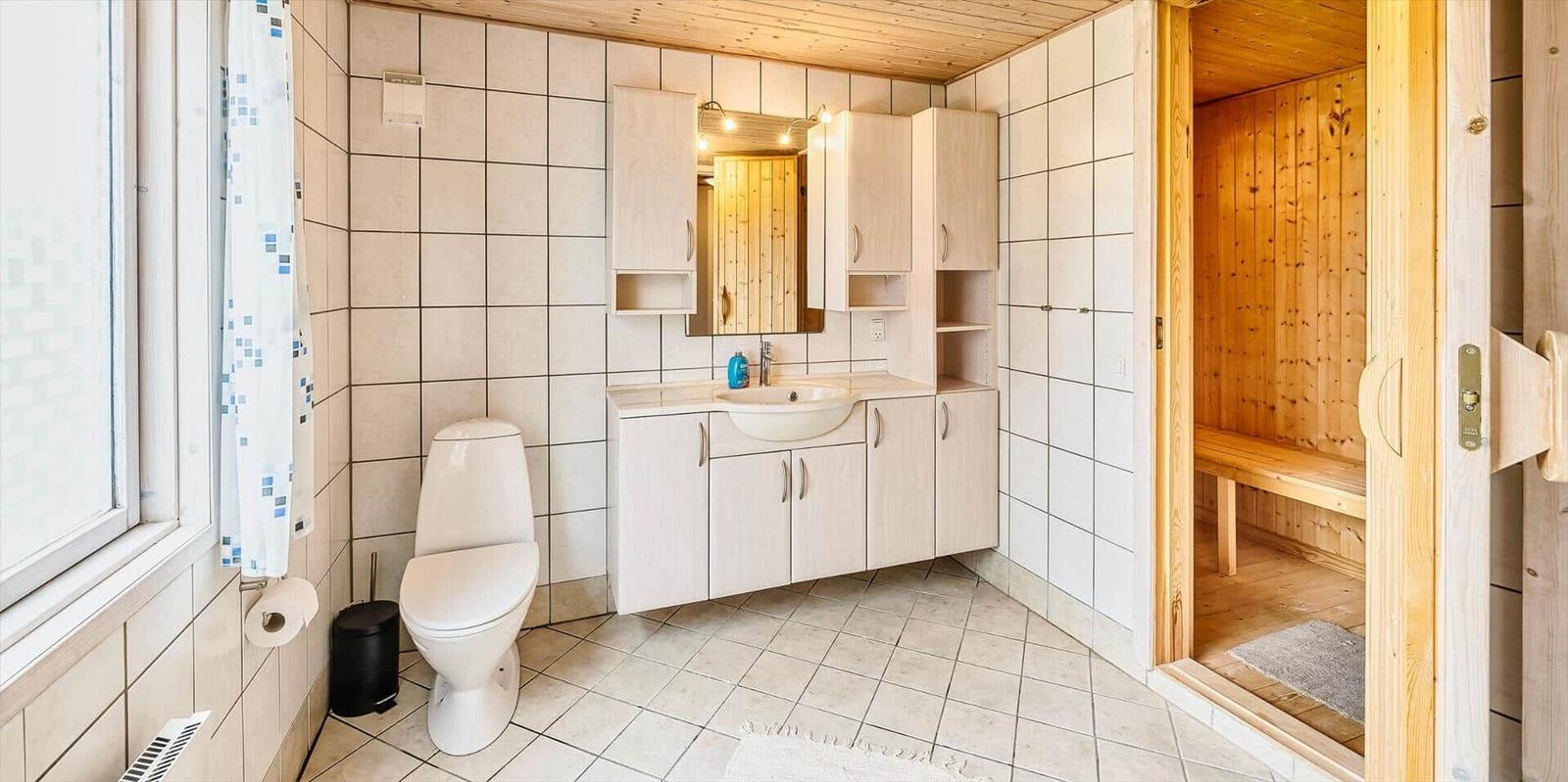 Badezimmer mit Toilette, Waschbecken und Sauna