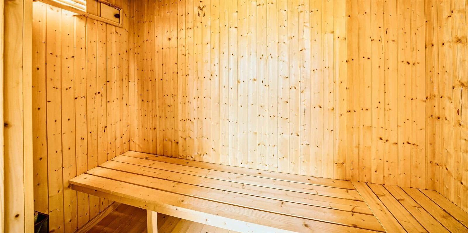 Sauna mit Holzwandverkleidung und Sitzbank.
