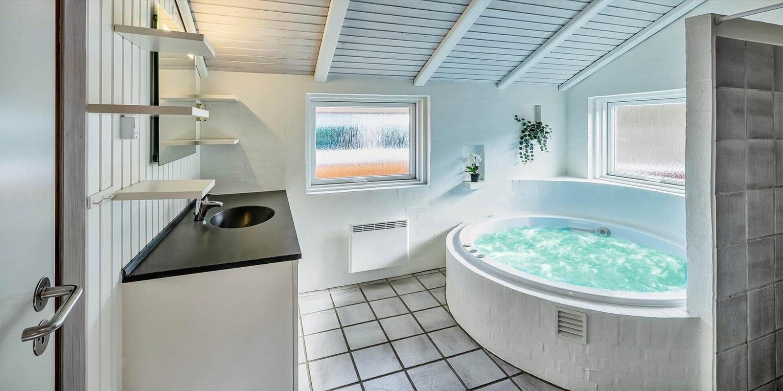 Bad mit Whirlpool, Waschbecken und Fenstern