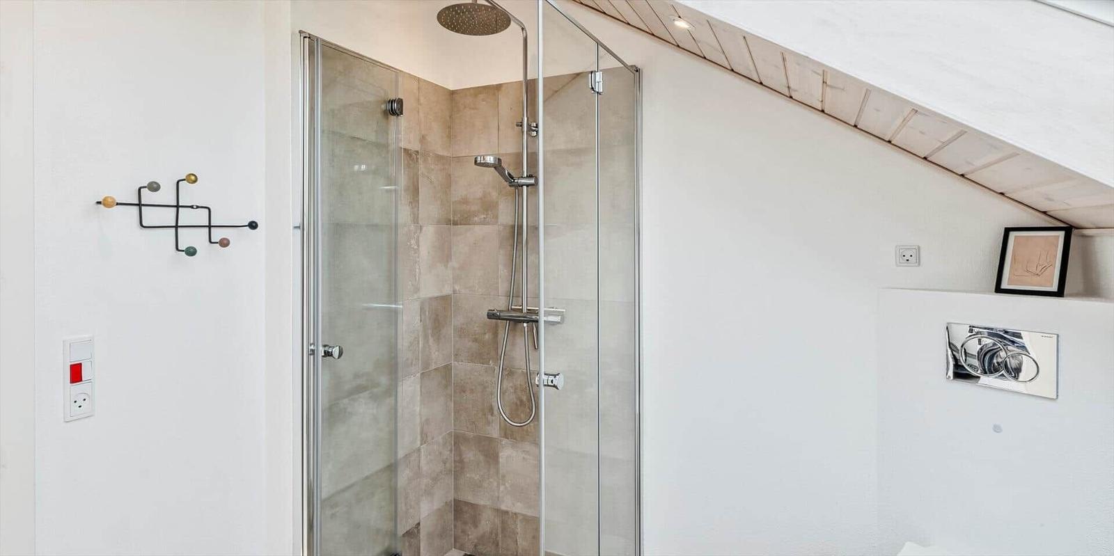 Dusche mit Glaswand, hellen Wänden und Holzdecke