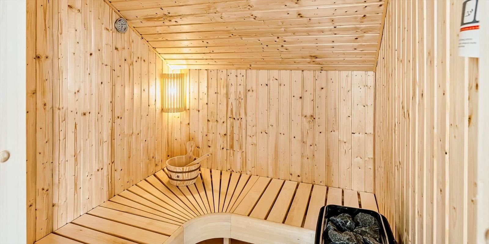 Sauna mit Holzbank, Eimer und Steine