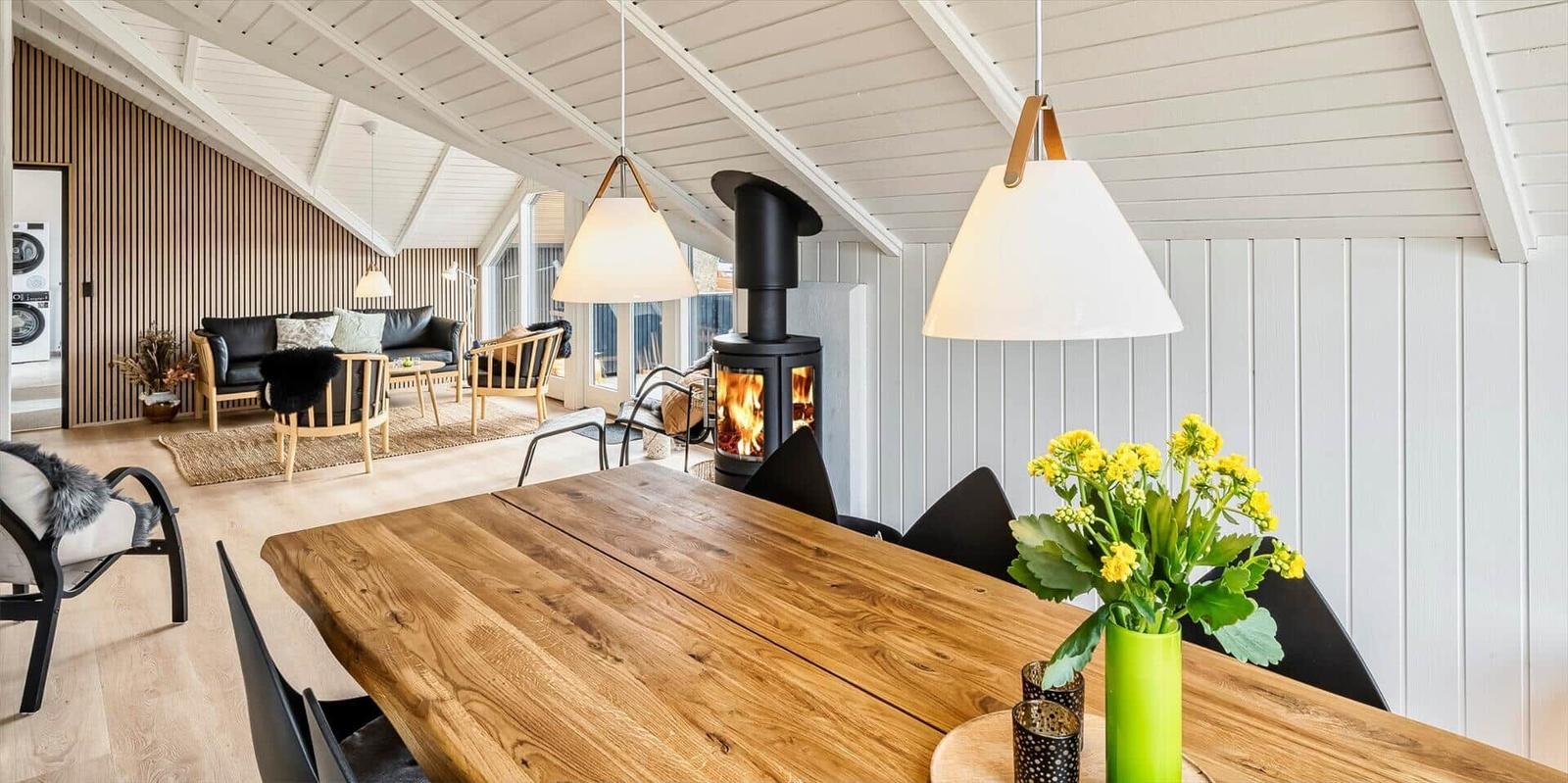 Essbereich mit Holztisch und Kamin im Wohnbereich.