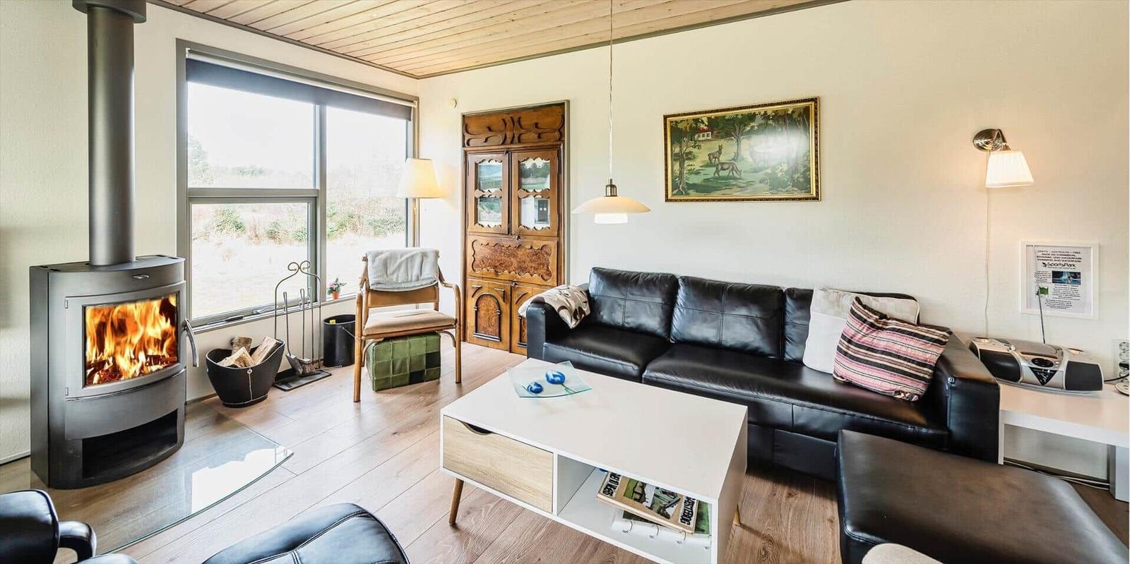 Wohnzimmer mit Kamin, Sofa und Holzboden.