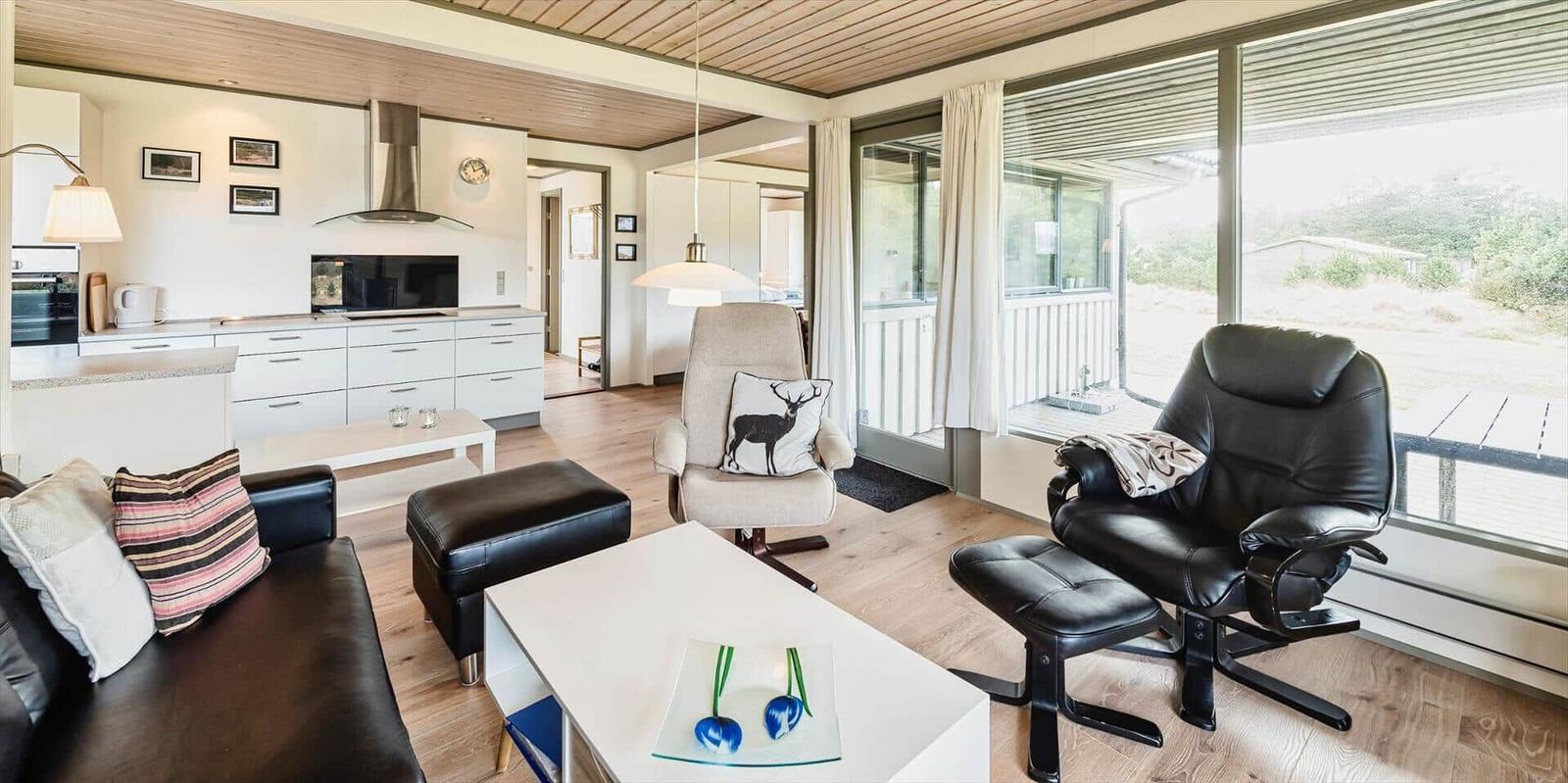 Wohnzimmer mit Küche, Sitzgelegenheiten und großem Fensterblick.