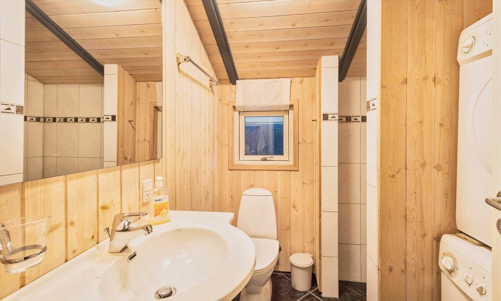 Badezimmer mit Waschbecken, Toilette und Waschmaschine