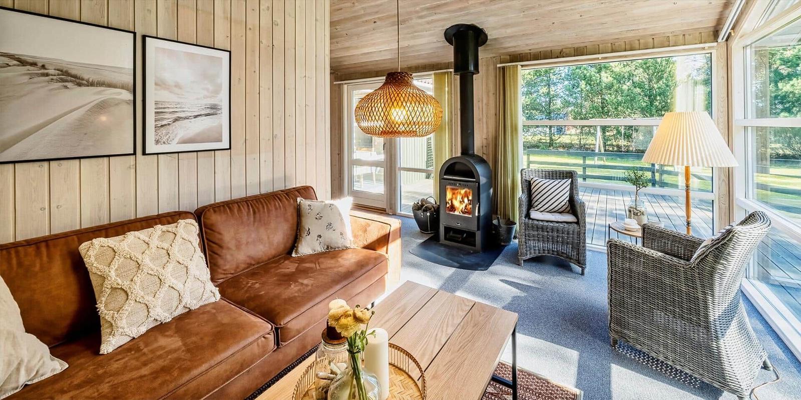 Wohnzimmer mit Sofa, Kamin und Blick auf Balkon