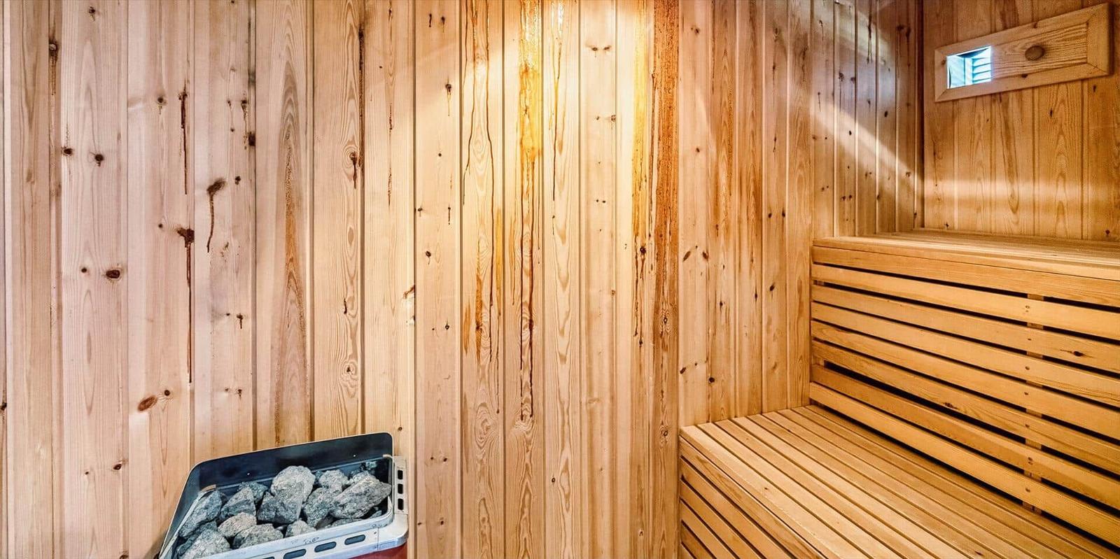 Sauna mit Holzwand und Sitzbänken, Heizung mit Steinen