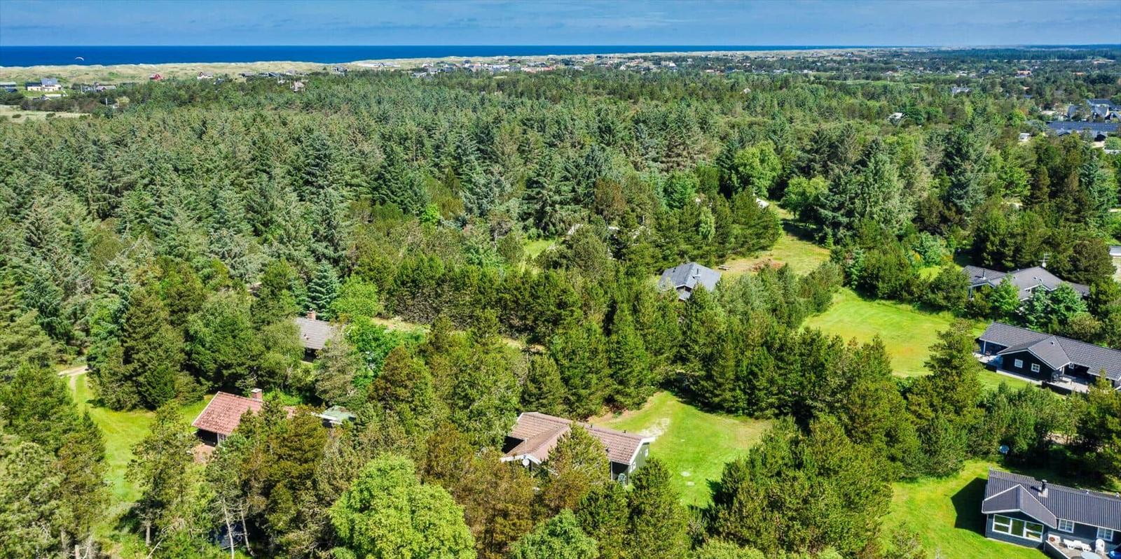 Wohnhäuser in einem Wald mit Blick auf das Meer