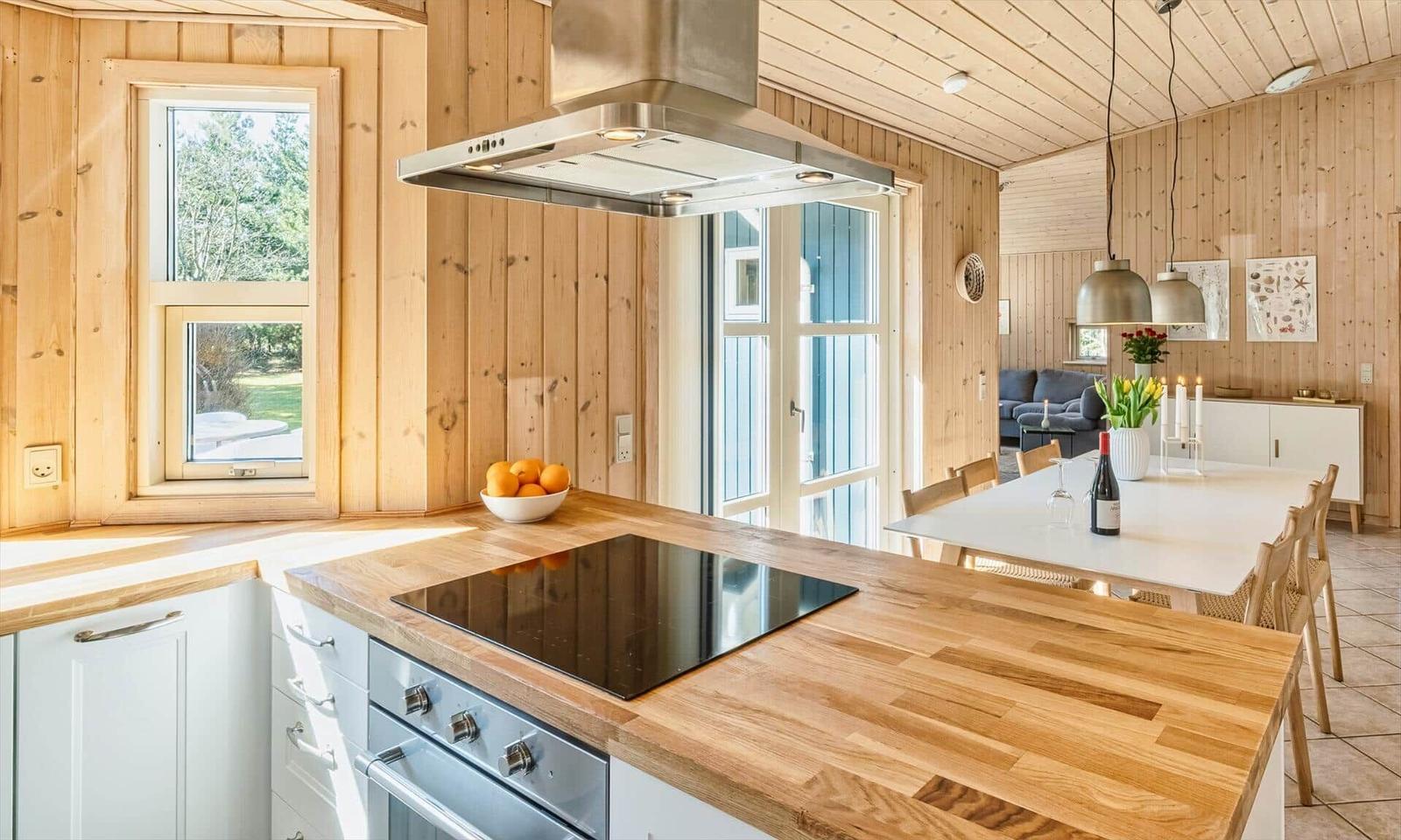 Küche mit Holzoberflächen und Essbereich mit Tisch und Stühlen.