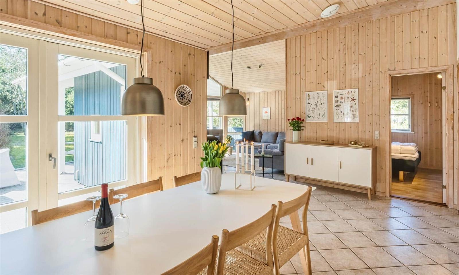 Essbereich mit Tisch, Stühlen und Fensterblick. Wohnzimmer und Schlafzimmer im Hintergrund.