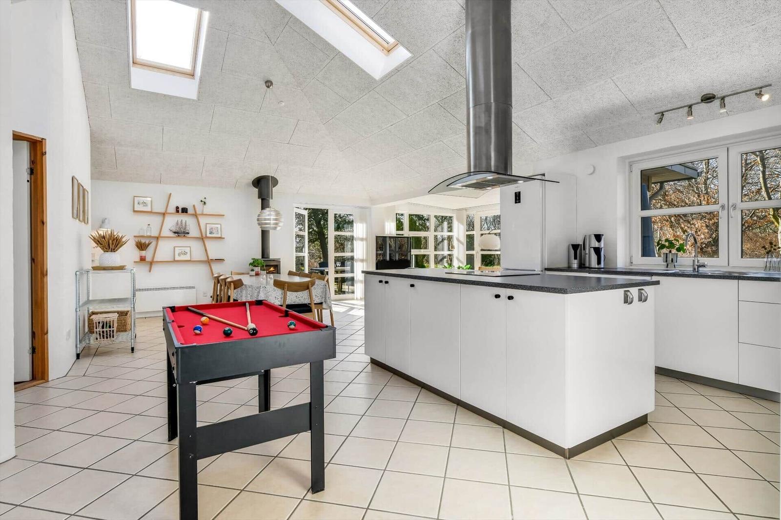 Küche mit Essbereich und Billardtisch. Dachfenster und Holztüren.