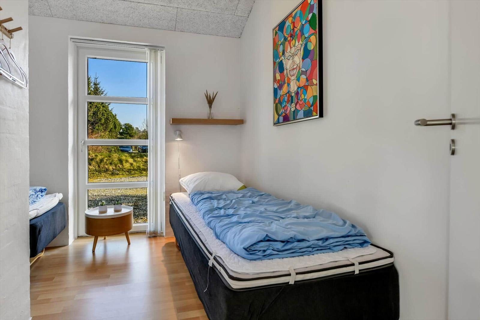 Ein Schlafzimmer mit einem Bett, einem Fenster und einer Wanddekoration.