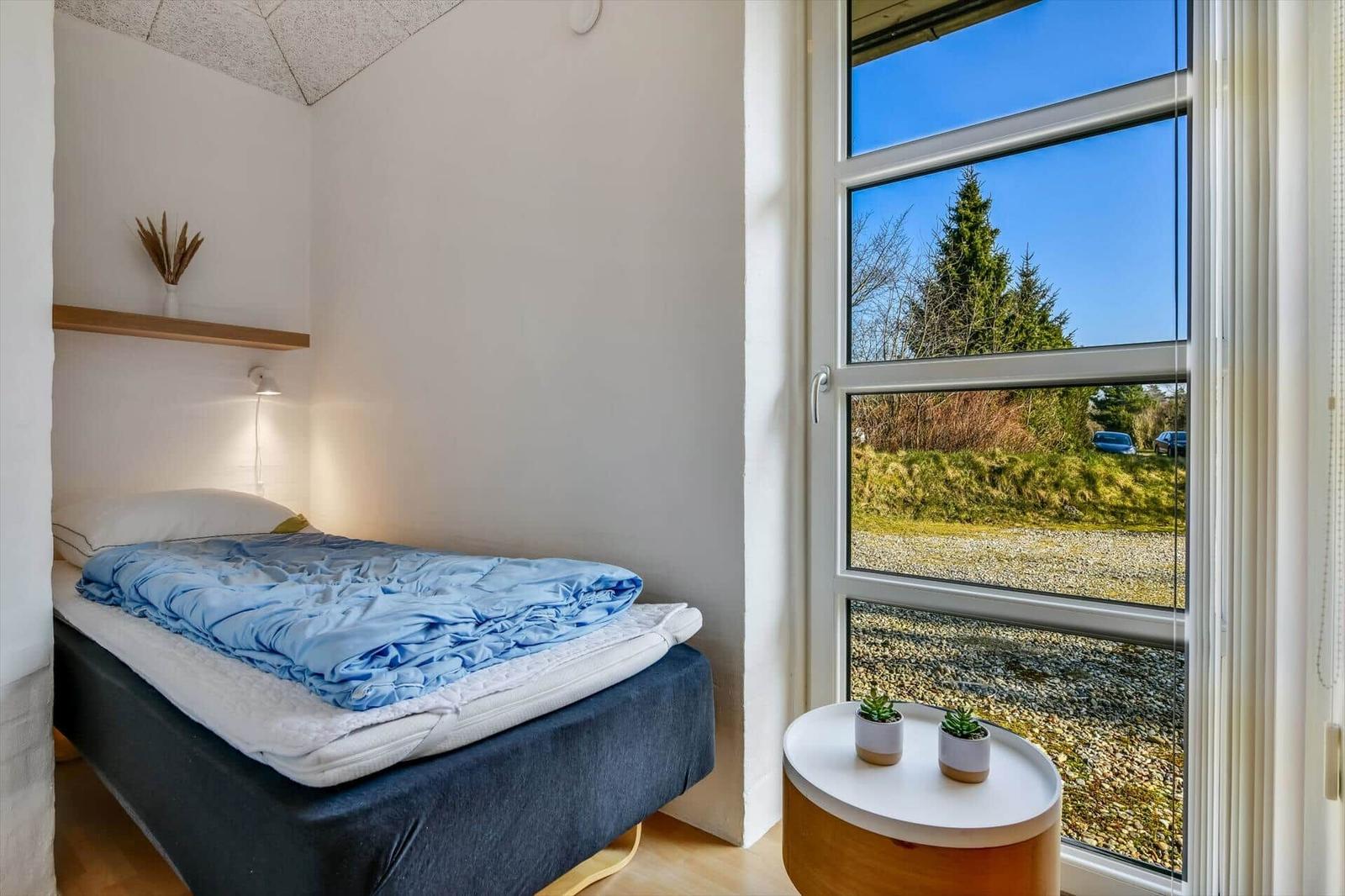 Schlafzimmer mit Bett, Fenster und Pflanzen
